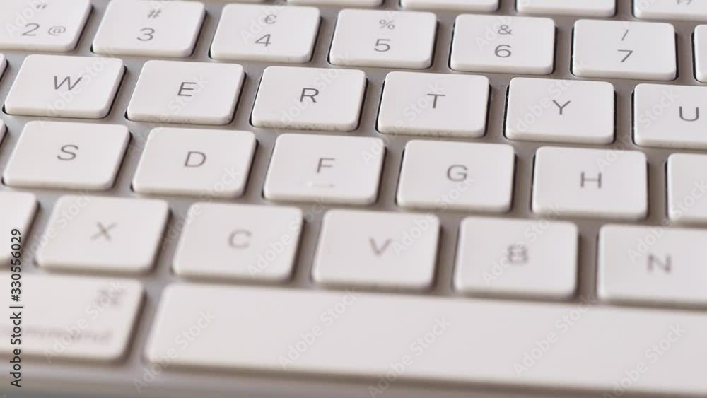 Slow right to left slide along white computer keyboard, close-up Slow right to left slide along white computer keyboard, close-up