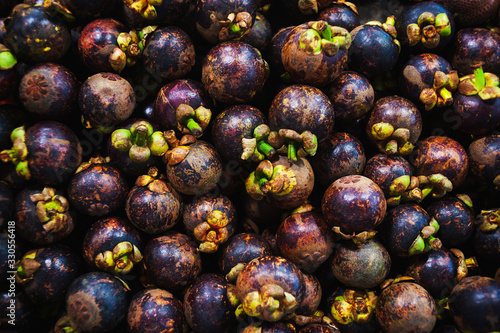 Plenty of fresh mangosteen on a counter in a market photo