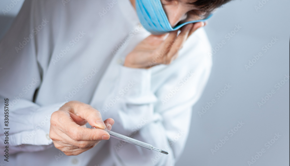 Coronavirus quarantine and Air pollution pm2.5 concept. Old sick woman wearing respirator mask for protect holds thermometer. Wuhan, China epidemic virus symptoms background. Coronavirus quarantine and Air pollution pm2.5 concept. Old sick woman wearing respirator mask for protect holds thermometer. Wuhan, China epidemic virus symptoms background.