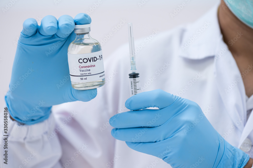 Doctor's hand holding syringe and bottle for vaccine to patient .Vaccination against coronavirus quarantine or covid-19.Protection against virus and infection control.Medication treatment concept. Doctor's hand holding syringe and bottle for vaccine to patient .Vaccination against coronavirus quarantine or covid-19.Protection against virus and infection control.Medication treatment concept.
