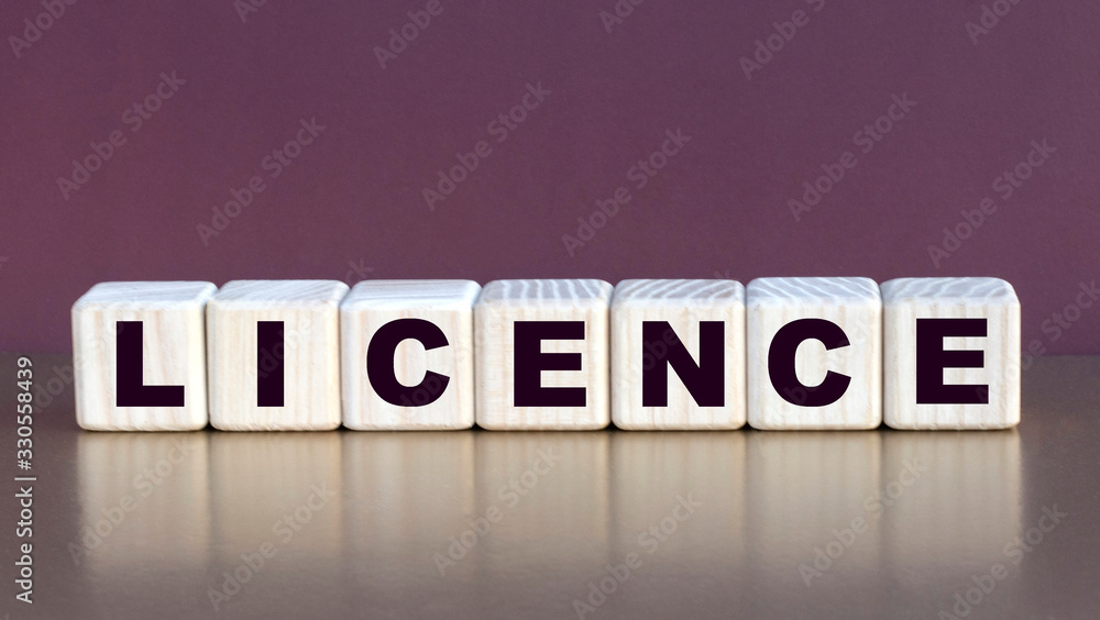Obraz premium LICENCE word on cubes on a burgundy background