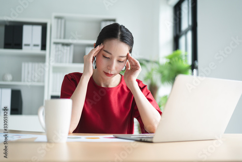 Slika na platnu Portrait of Asian beautiful office woman having headaches, stressful of work, depressed or having a fever while working at the office, concept of pressure from work, working lifestyle, stressful work