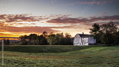 A white barn against the dawn sky in a rustic country scene