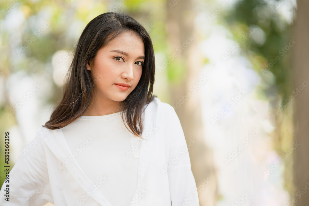 Portrait of young charming Asian woman wearing the white shirt in casual style and enjoy life in the natural sunlight in the park, Relaxing moment, enjoying the nature, mindful and feel the fresh are. Portrait of young charming Asian woman wearing the white shirt in casual style and enjoy life in the natural sunlight in the park, Relaxing moment, enjoying the nature, mindful and feel the fresh are.