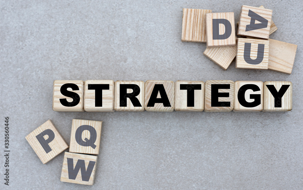 concept of the word STRATEGY on cubes on a gray background concept of the word STRATEGY on cubes on a gray background