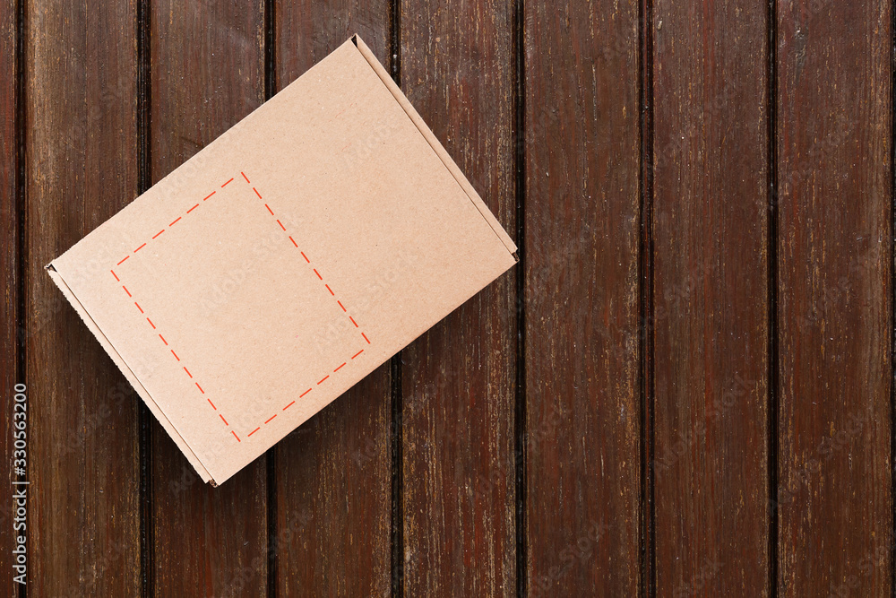 Fototapeta premium Cardboard box on a wooden background
