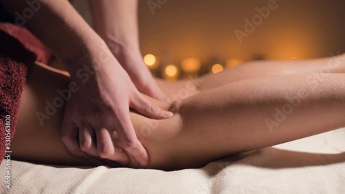 Wallpaper Mural Close-up of premium anti-cellulite thigh massage. Male hands do wellness massage of the thigh to the patient girl in a cozy study with dim light. Luxury massage services Torontodigital.ca