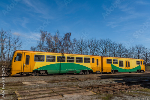Yellow color train in Kojetice na Morave station in winter sunny day