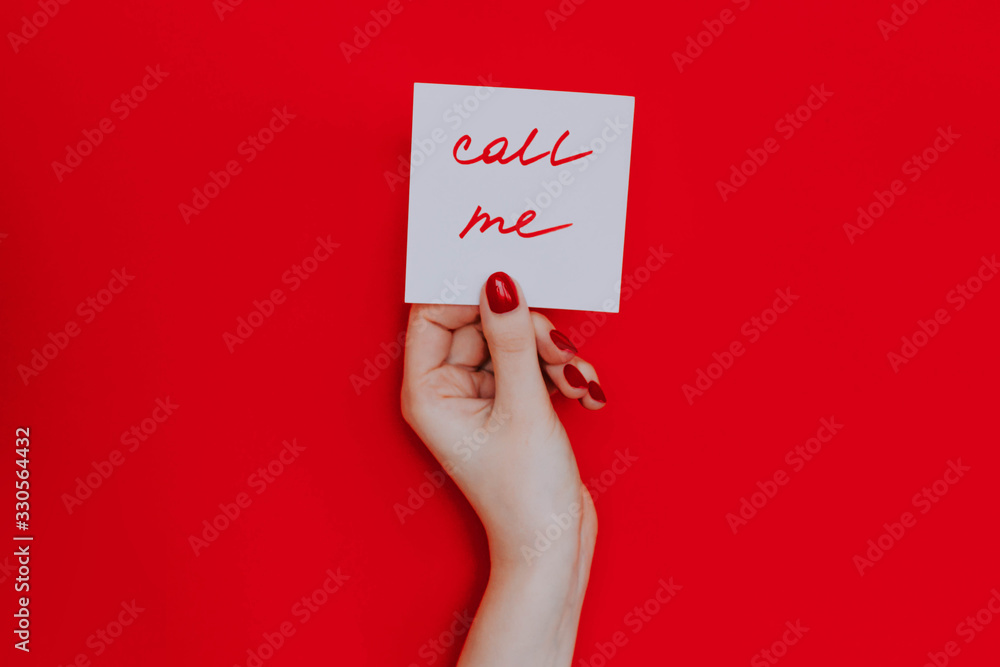 Note in a female hand with manicure, red nails. Note in a female hand with manicure, red nails.