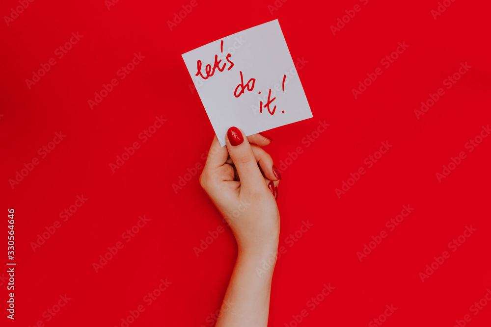Note in a female hand with manicure, red nails. Note in a female hand with manicure, red nails.