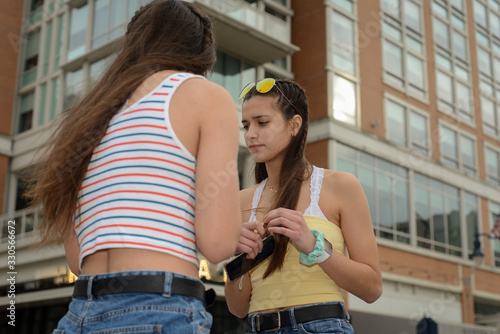 Two teenage girl friends in front of building