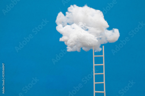 ladder or stairs leading up to a puffy cotton cloud on a dark blue background.