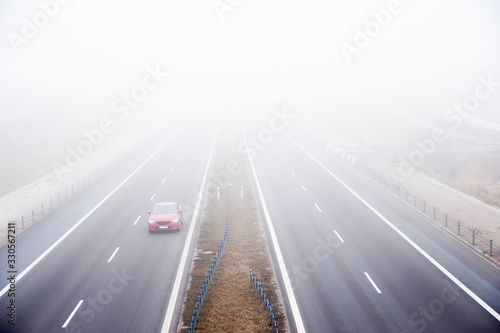 Cars ride fast on a highway in a misty cold day. Concept of road safety problem.