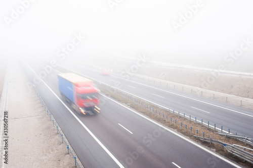 Lorry rides fast on a highway in a misty cold day. Concept of road safety problem.