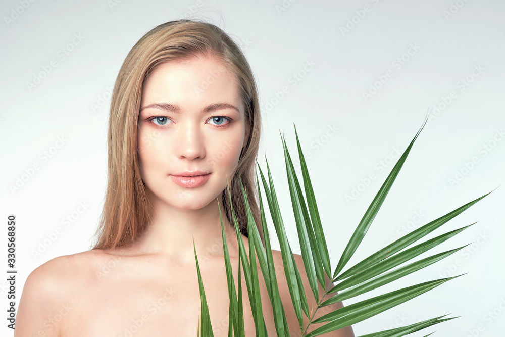 Natural organic skin care, the concept of harmony with nature, green long fern leaves grass near the face. portrait of beauty ladies. Young beautiful woman with clean sparkling skin of face and body. Natural organic skin care, the concept of harmony with nature, green long fern leaves grass near the face. portrait of beauty ladies. Young beautiful woman with clean sparkling skin of face and body.
