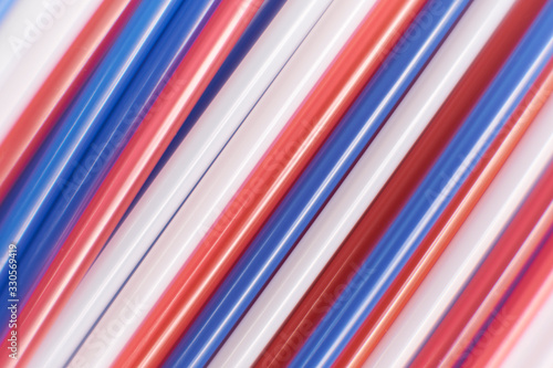 Colored cocktail plastic drinking straws rotates on white color background.