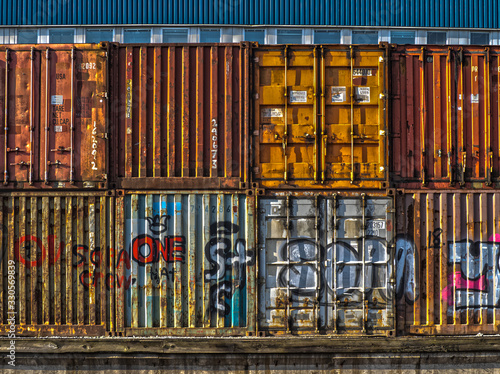 stack of multicoloured containers with grafitti