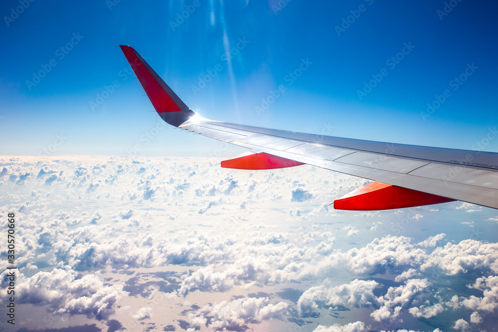 Fototapeta premium Plane wing window view sea clouds.