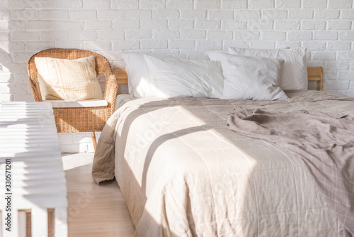 Home interior, bedroom in soft light colors with double bed, bedspread. pillows