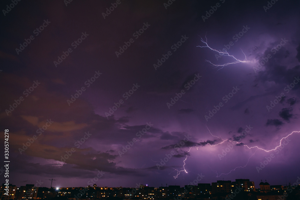 City view at night under thunderstorm with strike of lightning. Bad weather. 