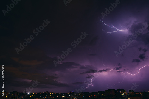 City view at night under thunderstorm with strike of lightning. Bad weather. 