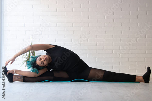 Fototapeta Naklejka Na Ścianę i Meble -  athlete woman doing gymnastic exercises or stretching at home or gym