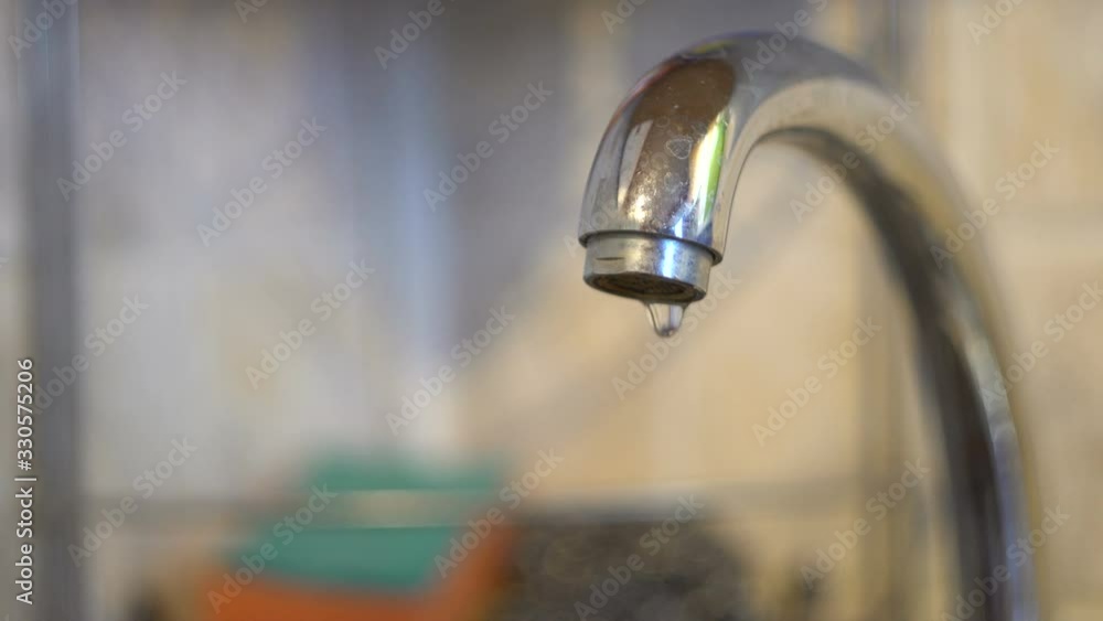Chrome tap in the kitchen. Dripping drops of water. Water pipes. Clean source. Filtered fluid. Macro. Close-up. Chrome tap in the kitchen. Dripping drops of water. Water pipes. Clean source. Filtered fluid. Macro. Close-up.