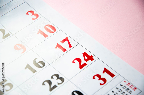 Macro calendar from different angles on a yellow and pink background. Black and red numbers on the calendar. Copy Space