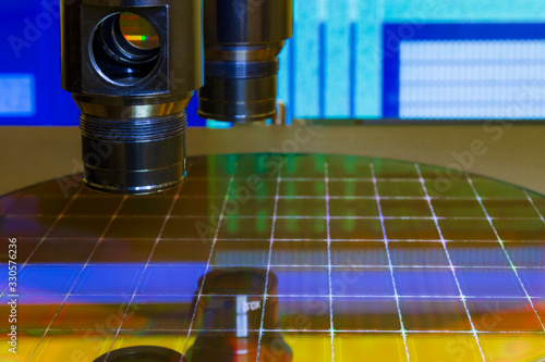 Silicon wafer with semiconductor microchip on machine process examining testing in microscope. photo