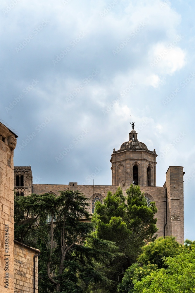 Girona, Spain, August 2018. Stormy sky over a tower with an angel on the roof.