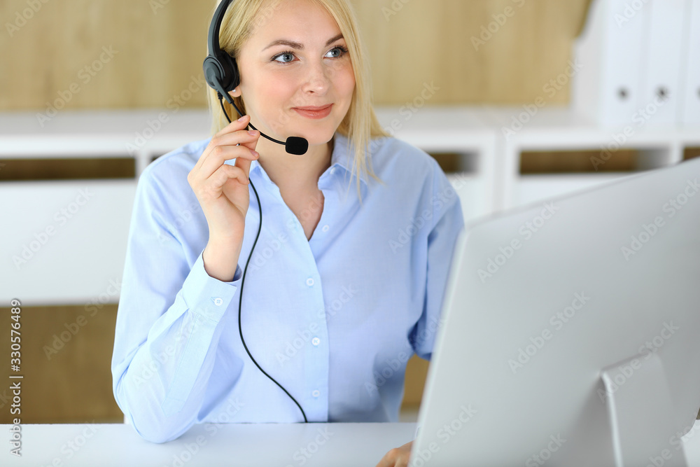 Call center. Blonde business woman sitting in headset at customer service office. Concept of telesales business or home office occupation Call center. Blonde business woman sitting in headset at customer service office. Concept of telesales business or home office occupation