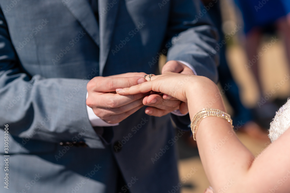 Detail of the hands of the bride and groom, the wedding rings and the passage of the wedding rings