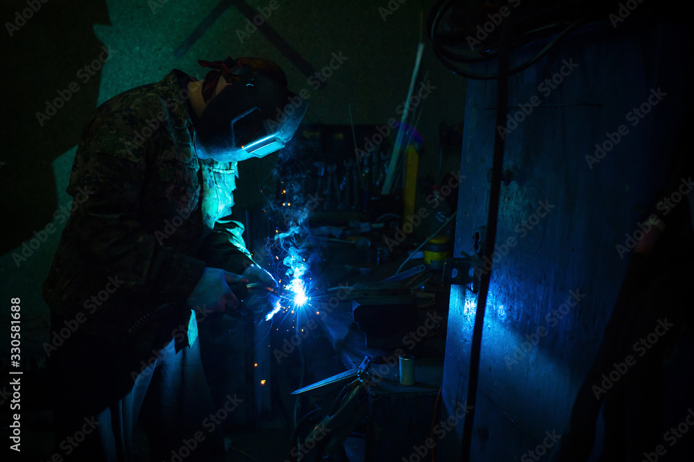 Welder at work in his workshop. Welder at work in his workshop.