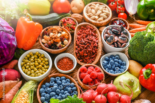 Fototapeta Naklejka Na Ścianę i Meble -  Healthy food eating variety selection in bowls: vegetables, fruits, berries, seeds, superfood, cereal, leaf vegetable on colorful background.