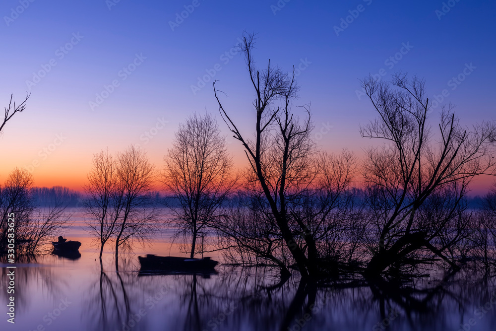 alba sul fiume Po il più grande d' Italia, con barche ormeggiate e sagome di alberi. alba sul fiume Po il più grande d' Italia, con barche ormeggiate e sagome di alberi.