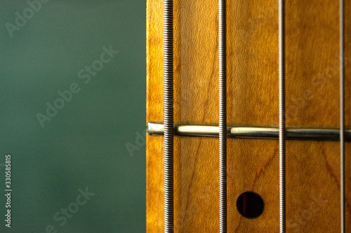 Section of bass guitar fretboard and strings extreme close up.