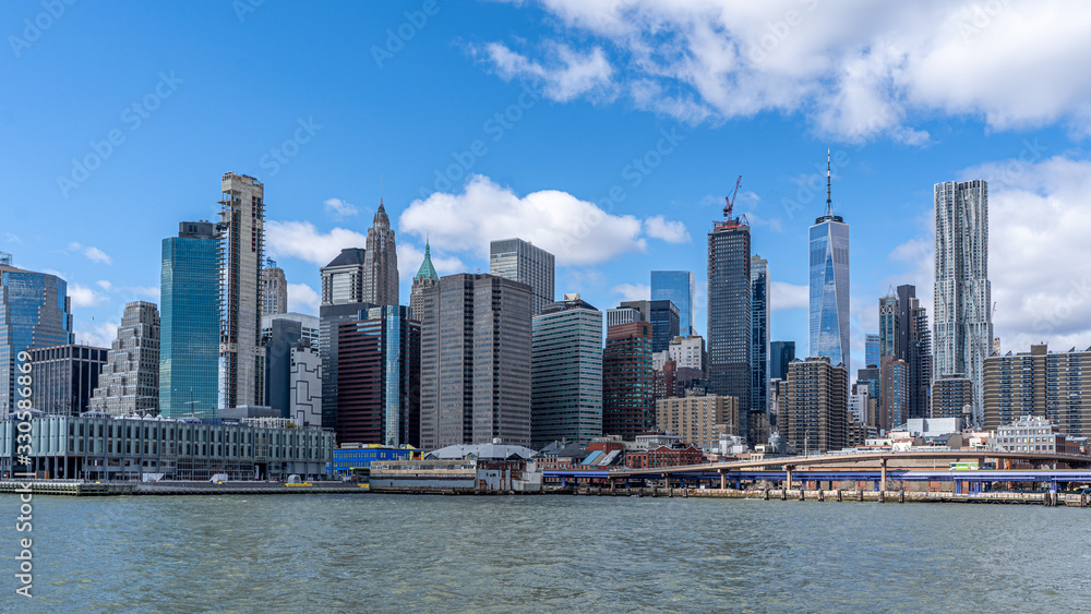 View of the manhattan skyline wall street financial district from a ferry on the hudson river View of the manhattan skyline wall street financial district from a ferry on the hudson river