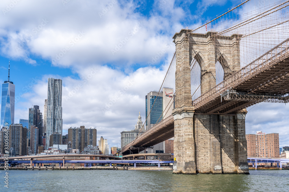 Obraz premium Brooklyn bridge shot from the water on a ferry with manhattan wall street behind new york city nyc USA