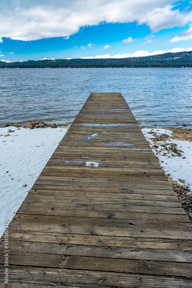 Wooden dock gang plank floats om a winter Idaho lake