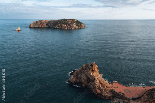 Scenic view of remote island with lighthouse photo