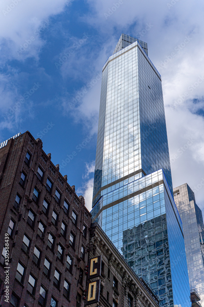 Reflections of the clouds on a glass skyscraper in new york city, scenic view from below