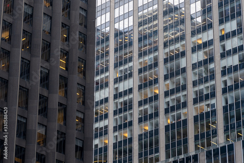 Detail close up of a glass skyscraper in Manhattan, New York City, close tu sunset on a sunny day. Black blue yellow and orange hues
