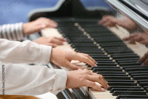 Private music teacher giving piano lessons to little boy, closeup