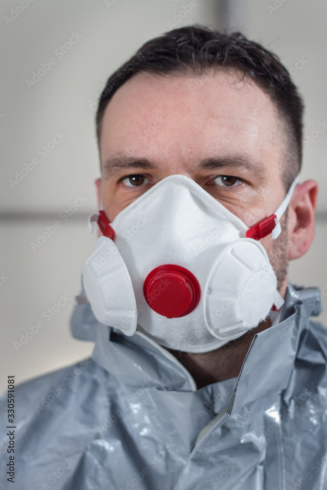 Twarz mężczyzny z maską ochronną na twarzy. Mężczyzna ubrany w kombinezon ochronny.