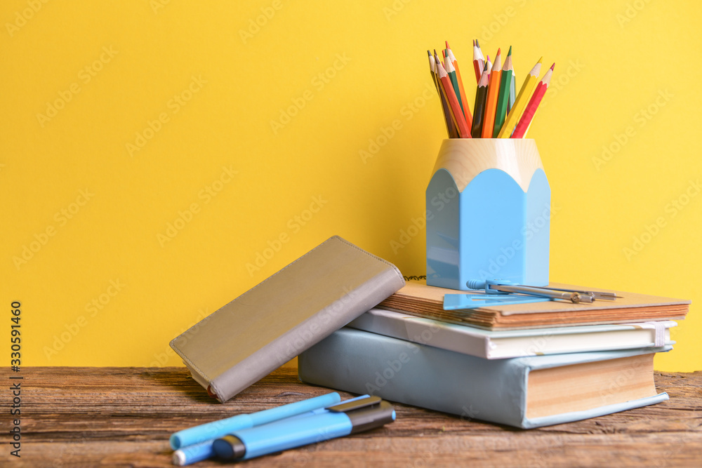 Fototapeta premium Set of school supplies on table against color background