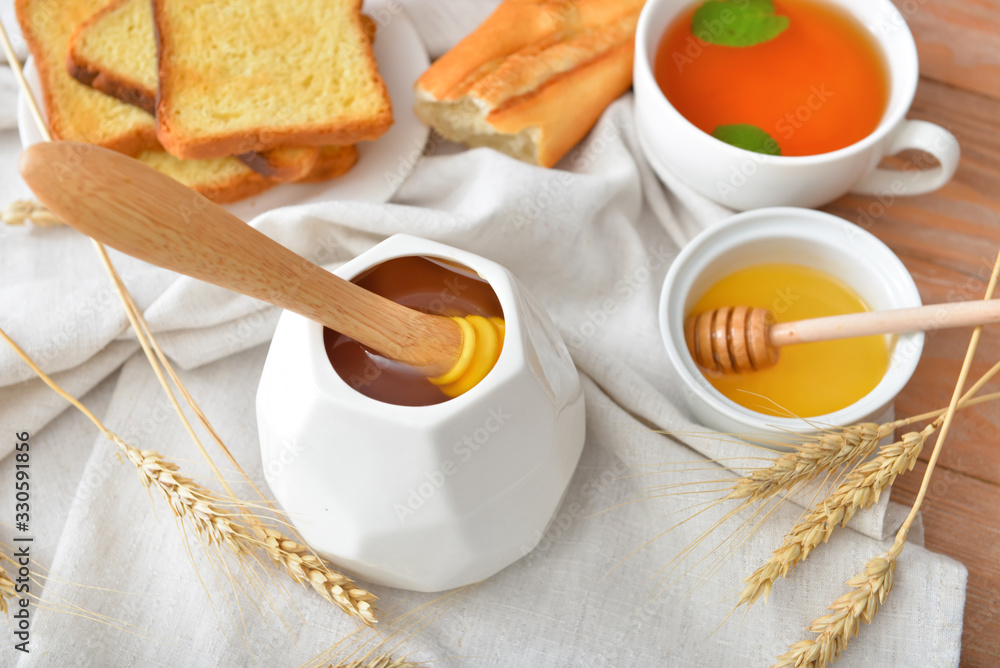 Tasty honey with bread and tea on table Tasty honey with bread and tea on table