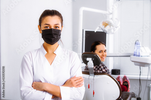 Doctor and patient in the dentistry office. Virologist. Virus. Coronavirus. in a black mask. Flu epidemic.