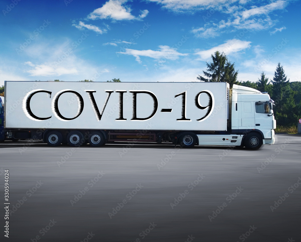 Big truck with a trailer and other trucks in motion against a sky with clouds Big truck with a trailer and other trucks in motion against a sky with clouds