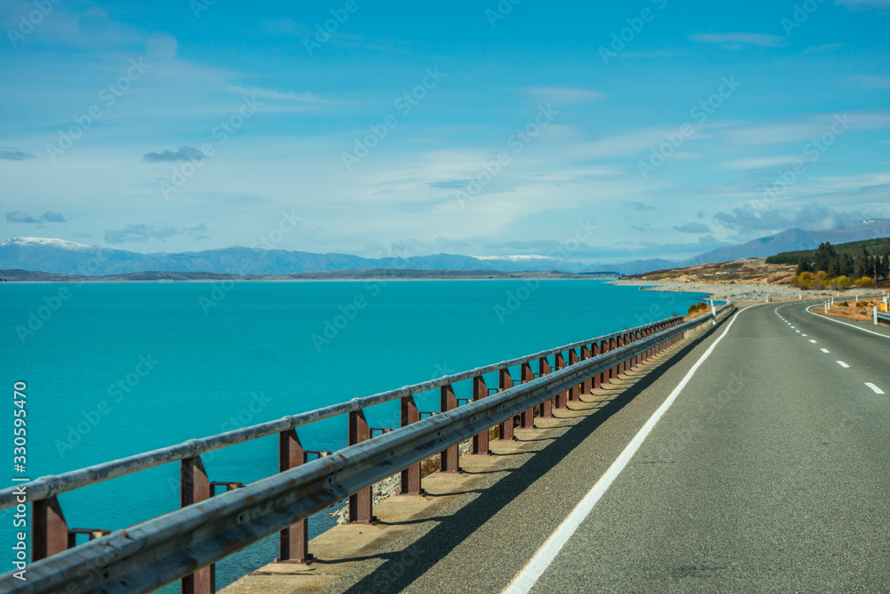 Eternal road with the bluish Pukaki Lake on the side, New Zealand