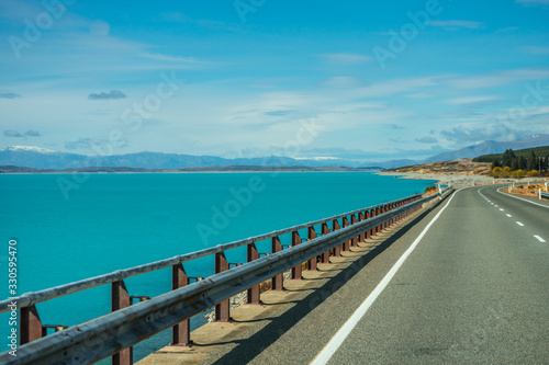 Eternal road with the bluish Pukaki Lake on the side  New Zealand